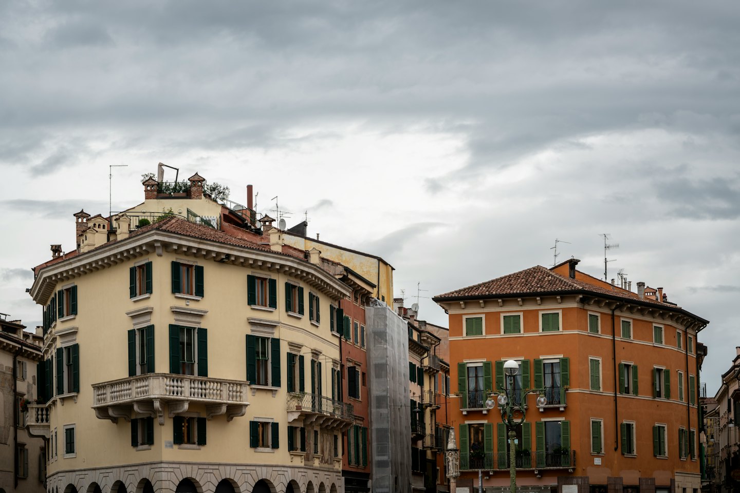 Edifici europei in stucco con tetti in terracotta e persiane verdi.